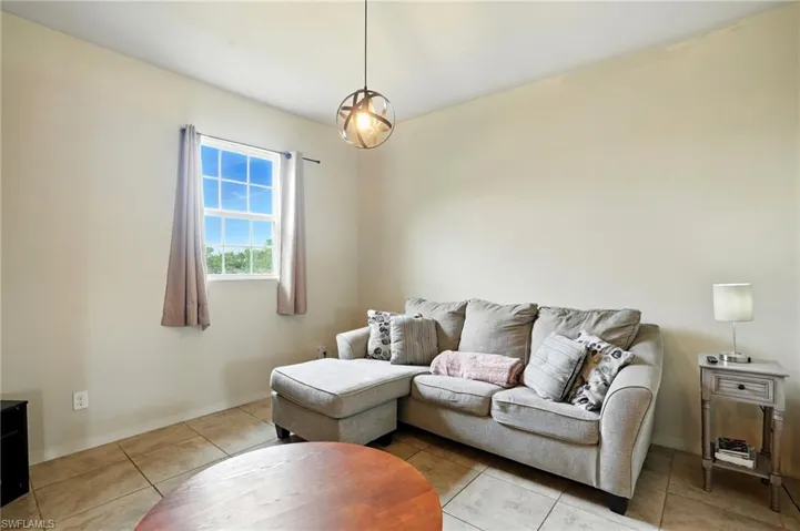 Tiled living room featuring baseboards
