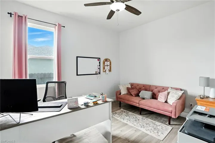 Office space with light wood finished floors and ceiling fan