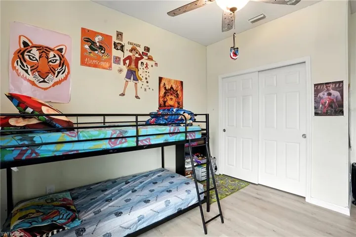 Bedroom with wood finished floors, a ceiling fan, and a closet