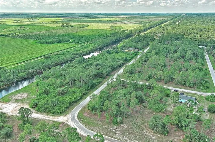 View of property location with rural landscape, a large body of water, and abundant farmland