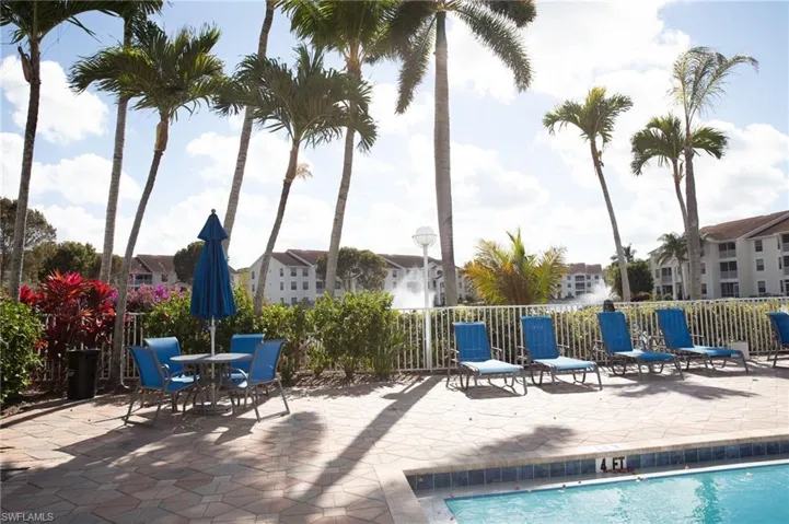 Community pool with a patio and outdoor dining area