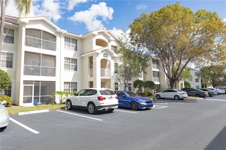 View of apartment building / complex with uncovered parking