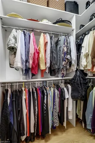 Walk in closet with wood-type flooring