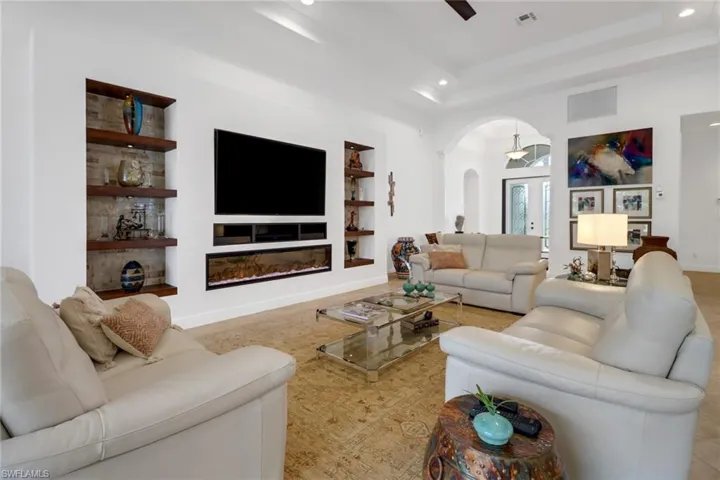 Living room featuring built in features and a tray ceiling