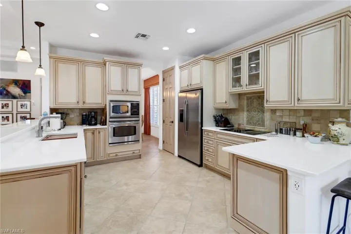 Kitchen with tasteful backsplash, light tile patterned floors, stainless steel appliances, and sink