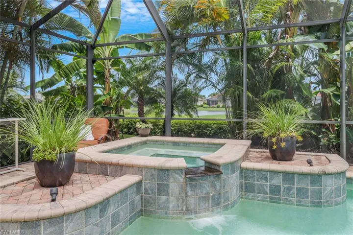 View of swimming pool featuring a lanai and an in ground hot tub