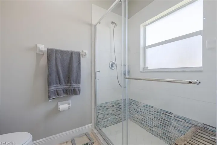 Master Bathroom featuring walk in shower with a wealth of natural light.