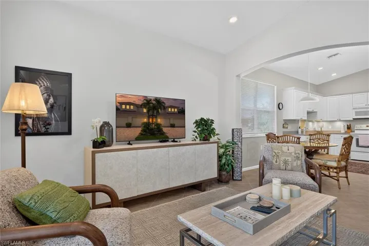 Open concept living space featuring vaulted ceilings and neutral wall tones