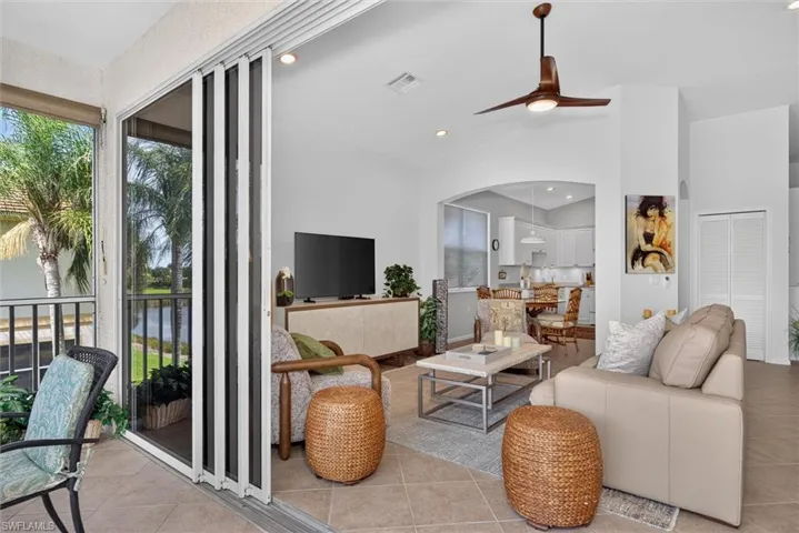 Expansive living area featuring tile flooring, a contemporary ceiling fan, and a wide arched entryway