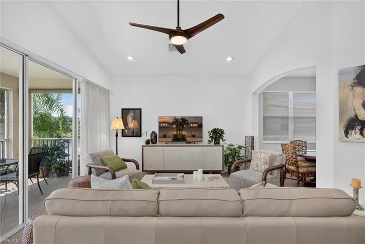 Vaulted ceiling living area featuring a contemporary ceiling fan, recessed lighting, and sliding glass doors leading to a private balcony