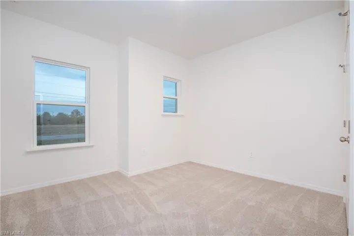 Spare room featuring healthy amount of natural light and light colored carpet