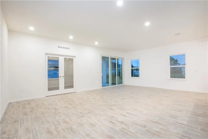 Unfurnished room featuring wood finish floors, french doors, and recessed lighting