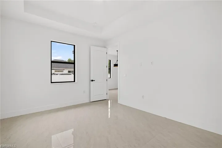 Spare room featuring a tray ceiling and baseboards