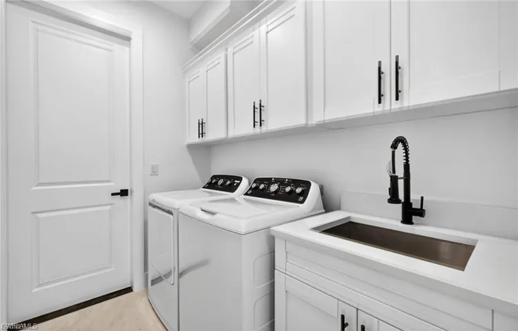 Laundry room featuring separate washer and dryer and cabinet space