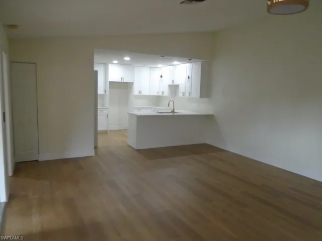 Unfurnished room featuring sink and hardwood / wood-style flooring