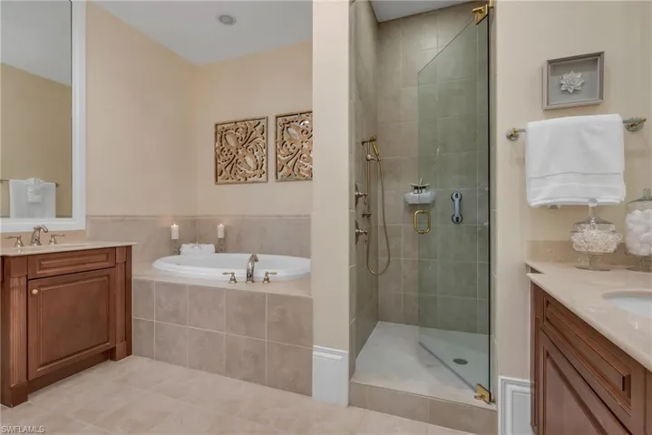 Owner's bath has double vanities, frameless shower doors, and large, soaking tub, which is perfect after a full day of golfing!