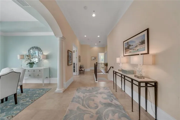 Hallway from living room to front guest suite and den, with the elevator at end of hallway.