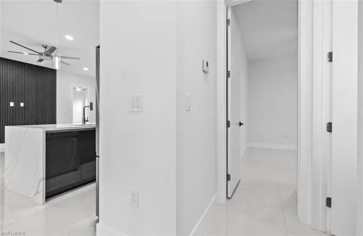 Hallway featuring light marble finish floors and recessed lighting