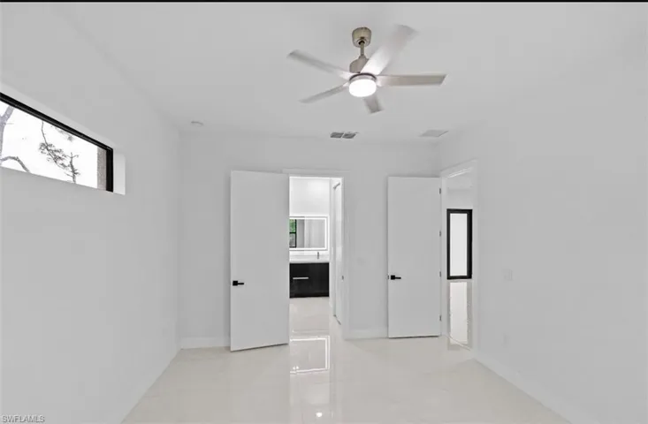 Empty room featuring ceiling fan and baseboards