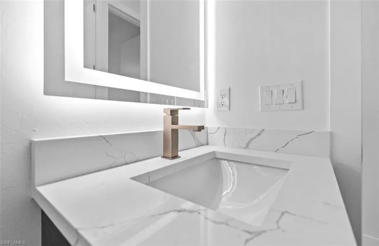 Bathroom view of vanity and a textured wall