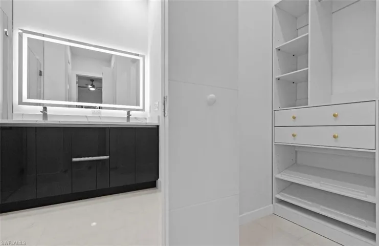 Bathroom with double vanity and ceiling fan