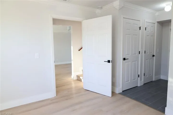 Unfurnished bedroom featuring wood finished floors and ornamental molding