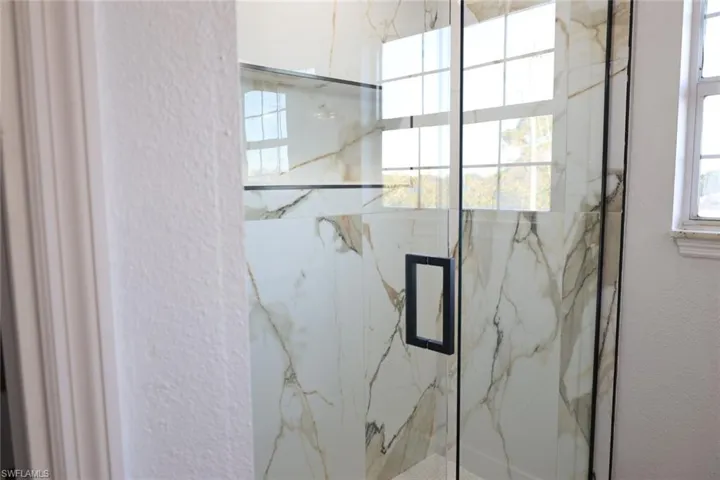 Bathroom with a marble finish shower