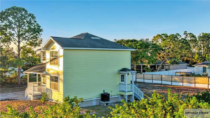 Property exterior at dusk with a shingled roof and a cooling unit