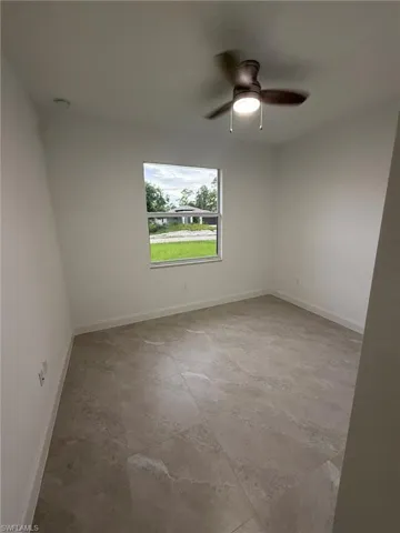 Spare room featuring baseboards and ceiling fan