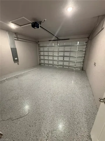 Garage featuring electric panel and a garage door opener