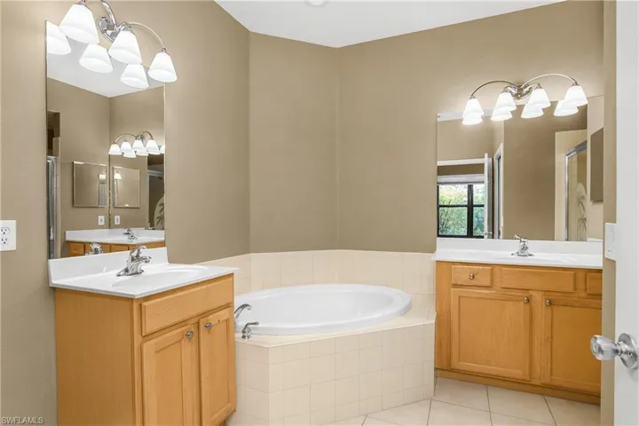 Primary bath with dual vanities, soaking tub, walk-in shower, and private water closet.