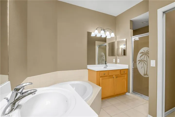 Primary bath with dual vanities, soaking tub, walk-in shower, and private water closet.