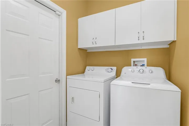 Laundry Room with additional storage space is located adjacent to the garage entry.