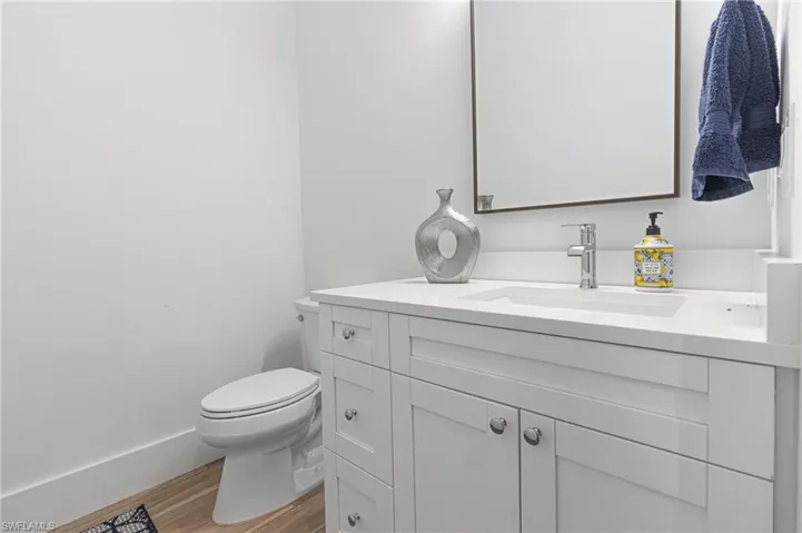 Bathroom featuring wood-type flooring, vanity, and toilet