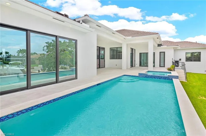 View of swimming pool with a patio area and an in ground hot tub