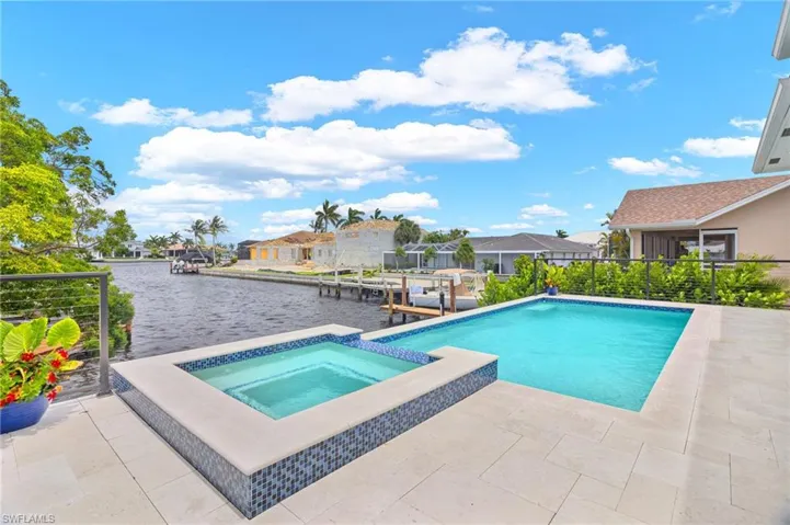 View of swimming pool featuring a patio area and an in ground hot tub