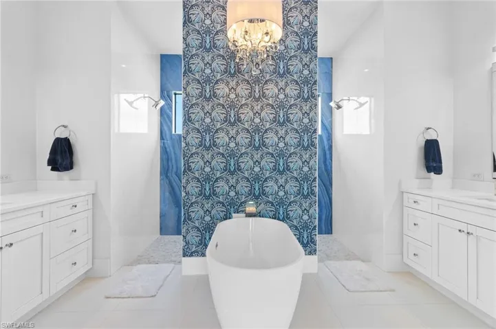 Bathroom featuring a tile shower, tile flooring, and vanity