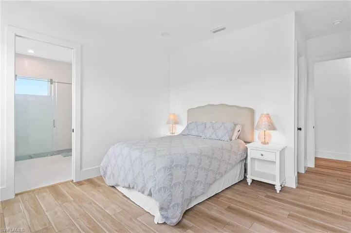 Bedroom with connected bathroom and light hardwood / wood-style floors