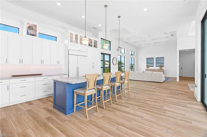 Kitchen with white cabinets, coffered ceiling, and light wood-type flooring