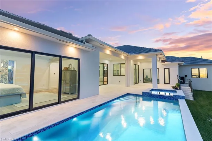 Pool at dusk featuring a patio