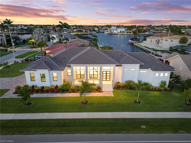 View of front of house with a lawn and a water view