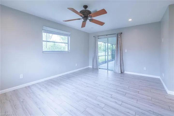Empty room with light hardwood / wood-style floors, plenty of natural light, and ceiling fan
