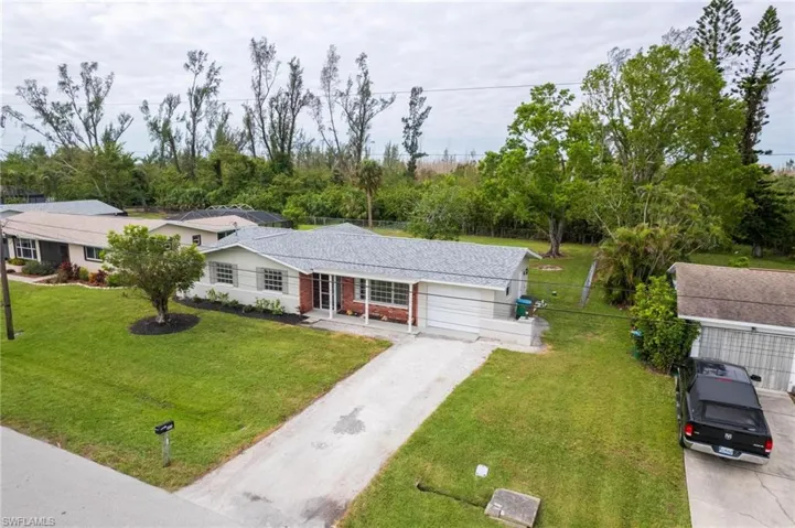 Ranch-style house with a garage and a front lawn