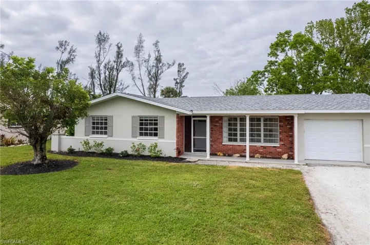 Ranch-style house featuring a garage and a front yard