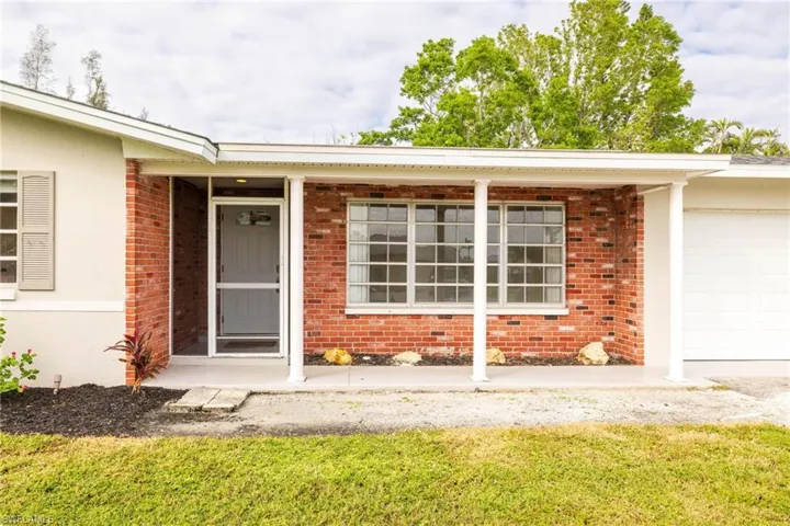 Property entrance with a yard and a garage
