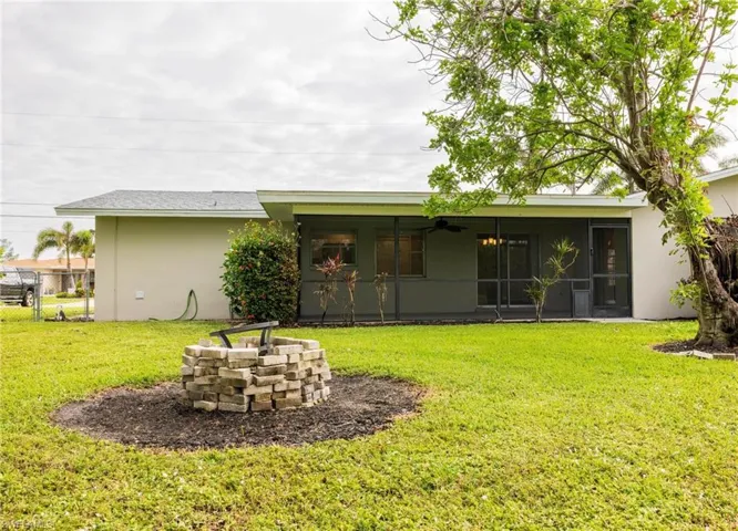 Back of property featuring a sunroom and a lawn