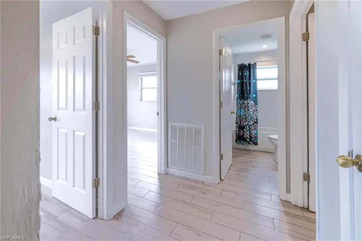 Hallway with light wood-type flooring and a wealth of natural light