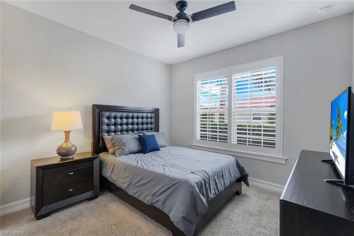 Carpeted bedroom featuring ceiling fan