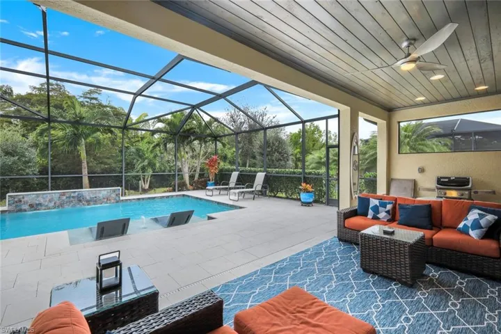 View of swimming pool featuring an outdoor hangout area, a patio, a lanai, grilling area, and pool water feature