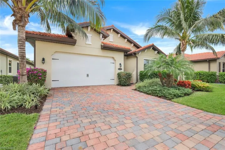 Mediterranean / spanish home with central AC unit and a garage